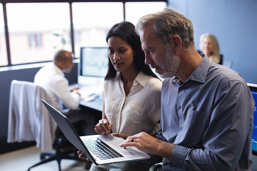 Business professionals reviewing a contract, emphasizing the risks of a do-it-yourself approach to selling a business.